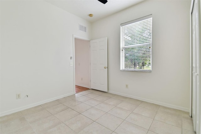 tiled spare room with ceiling fan