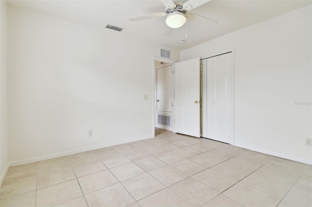 unfurnished bedroom with ceiling fan, a closet, and light tile patterned floors