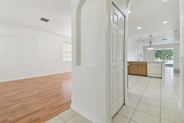 hallway featuring light tile patterned floors and sink