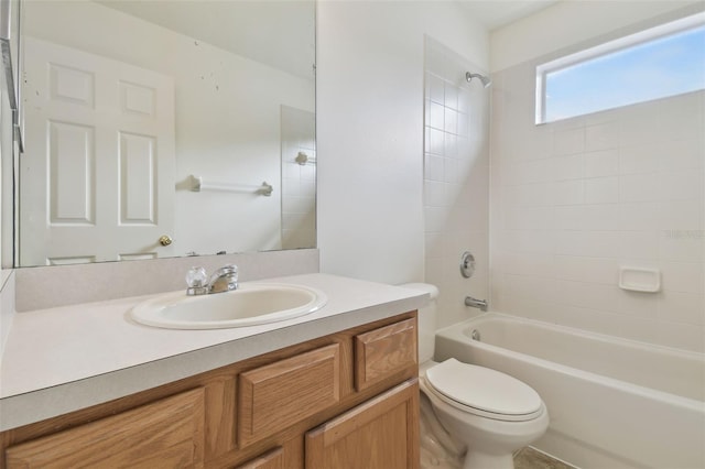 full bathroom featuring tiled shower / bath combo, vanity, and toilet