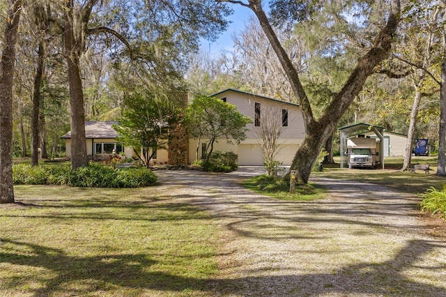 view of front of property with a front yard, a garage, and a carport