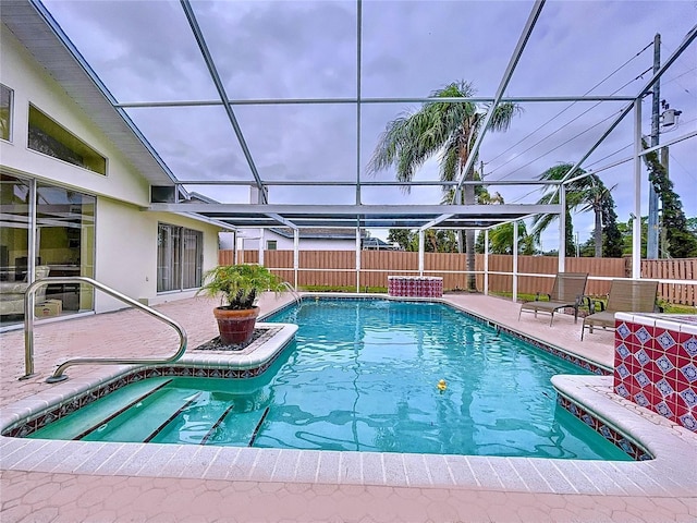 view of pool featuring glass enclosure and a patio area