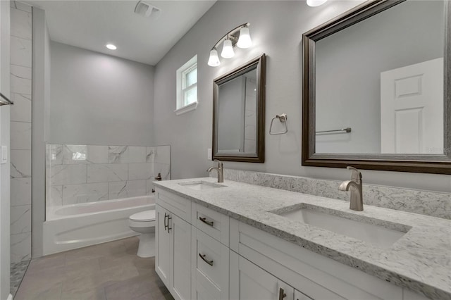 bathroom with a tub, toilet, vanity, and tile patterned floors