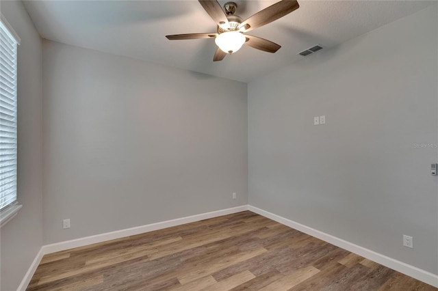 empty room featuring light wood-type flooring, ceiling fan, and a wealth of natural light