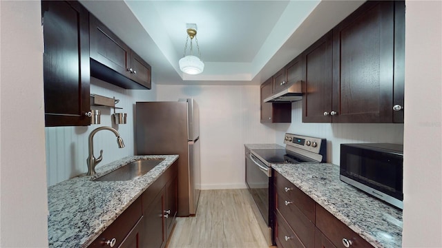 kitchen with light hardwood / wood-style floors, sink, appliances with stainless steel finishes, decorative light fixtures, and light stone countertops