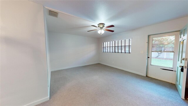 carpeted spare room featuring ceiling fan