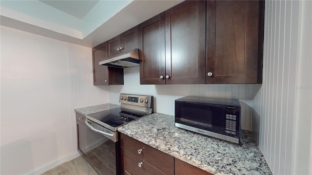 kitchen with dark brown cabinets, light stone counters, light hardwood / wood-style floors, and appliances with stainless steel finishes