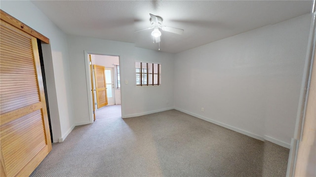 carpeted empty room featuring ceiling fan