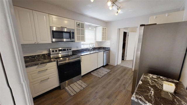 kitchen featuring tasteful backsplash, white cabinetry, dark wood-type flooring, and stainless steel appliances