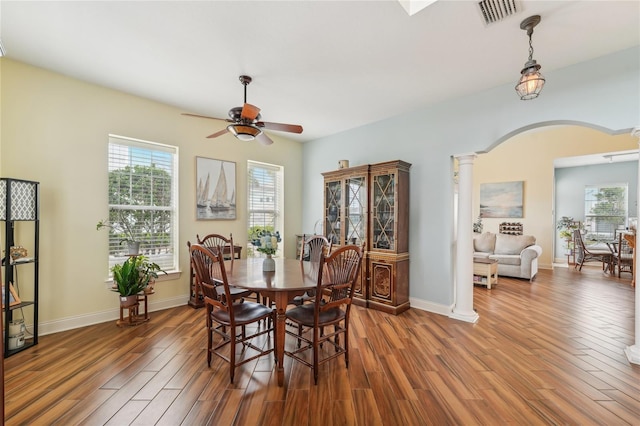 dining area featuring ceiling fan, dark hardwood / wood-style floors, and decorative columns