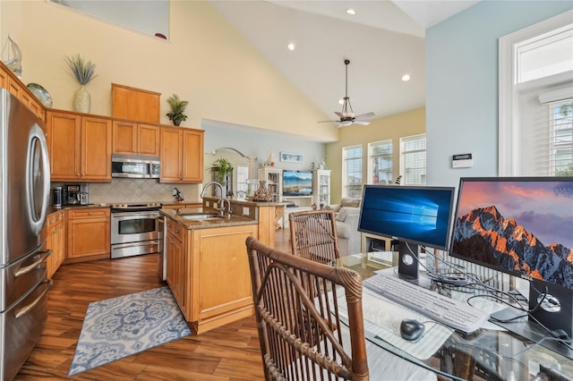 kitchen with a center island with sink, ceiling fan, stainless steel appliances, and plenty of natural light