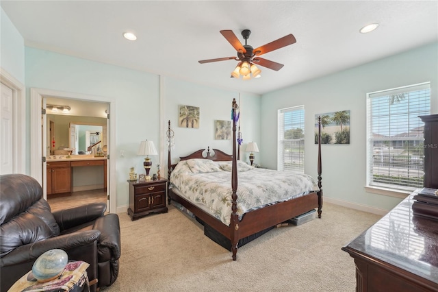 carpeted bedroom with ensuite bath and ceiling fan