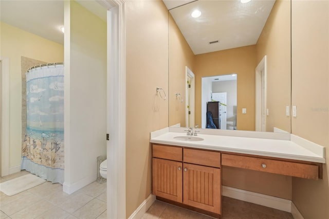 bathroom featuring vanity, tile patterned flooring, and toilet