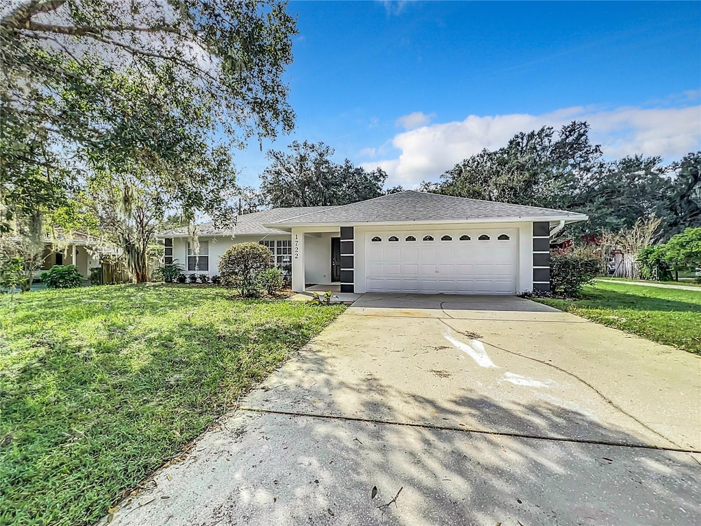 ranch-style house featuring a front yard and a garage