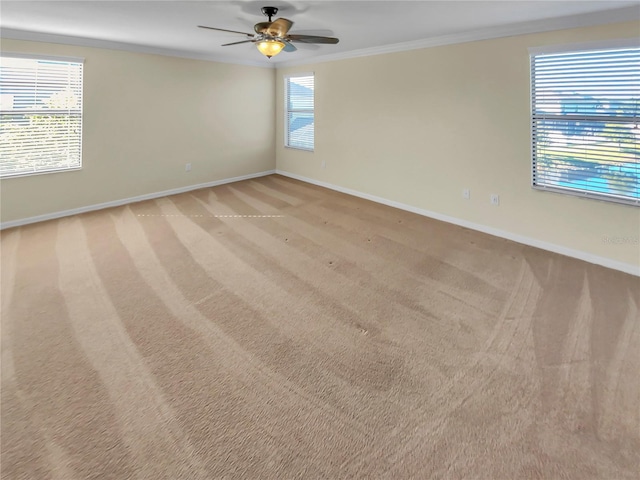 empty room with crown molding, ceiling fan, and light colored carpet