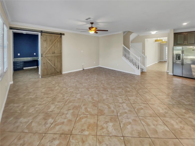 unfurnished living room with a barn door, ornamental molding, and ceiling fan