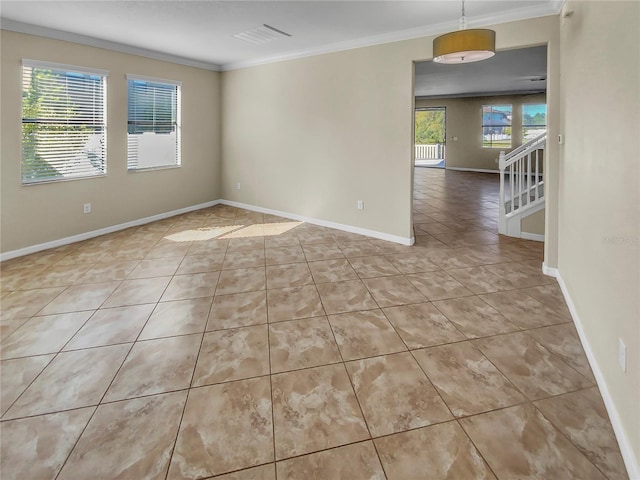 empty room featuring crown molding and a wealth of natural light