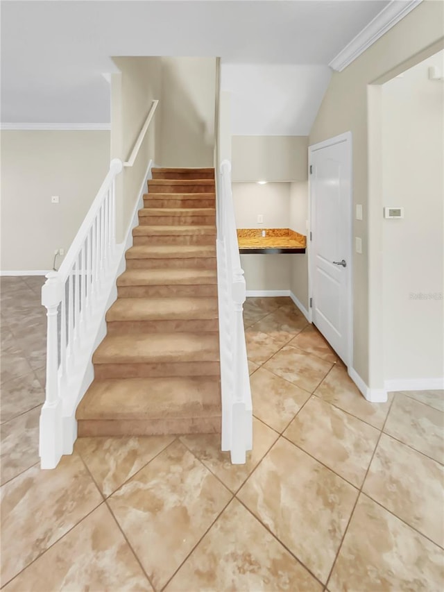 staircase featuring lofted ceiling, ornamental molding, and tile patterned flooring