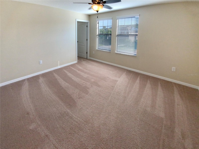 empty room featuring ceiling fan and light carpet