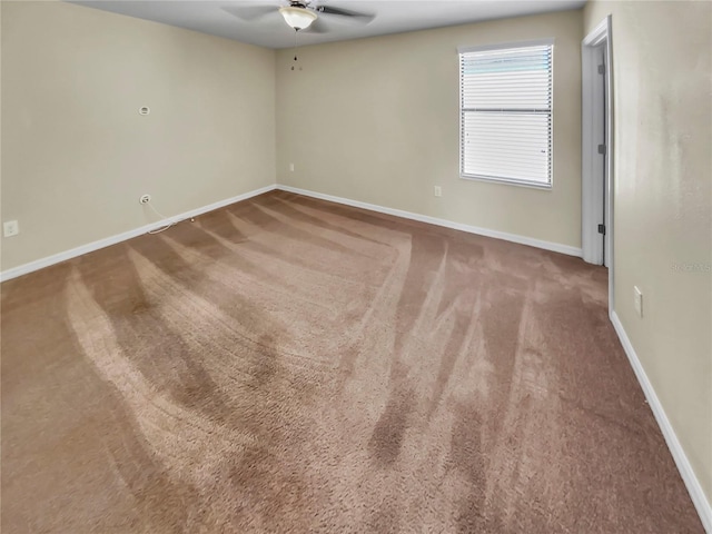 carpeted spare room featuring ceiling fan