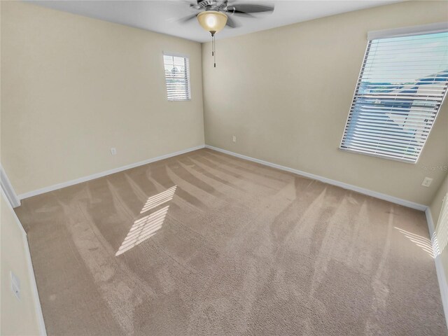 carpeted spare room with ceiling fan