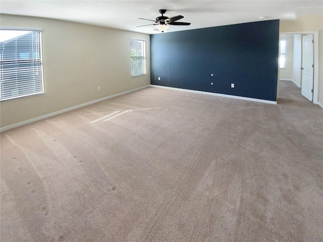 carpeted spare room with ceiling fan