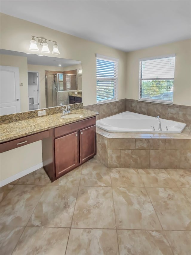 bathroom with shower with separate bathtub, vanity, and tile patterned floors