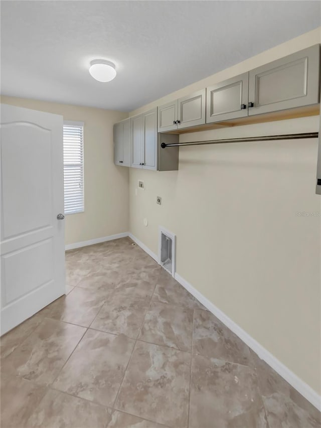 clothes washing area with cabinets, electric dryer hookup, and gas dryer hookup