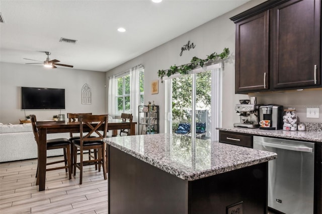 kitchen featuring light hardwood / wood-style floors, light stone counters, ceiling fan, dark brown cabinetry, and stainless steel dishwasher