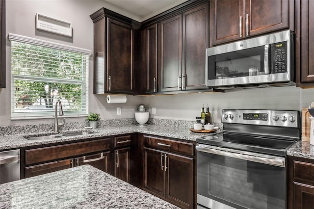 kitchen with dark brown cabinetry, appliances with stainless steel finishes, and sink