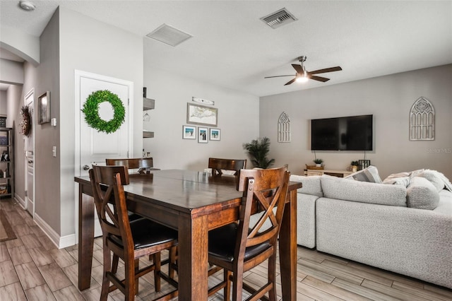 dining room with a textured ceiling, light hardwood / wood-style floors, and ceiling fan