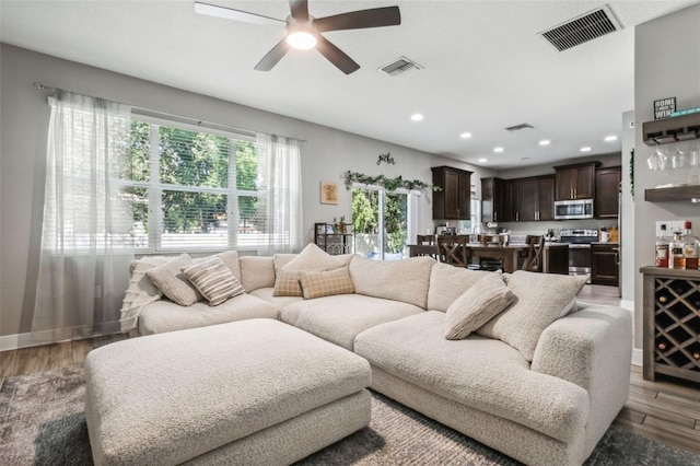 living room featuring ceiling fan and light hardwood / wood-style floors