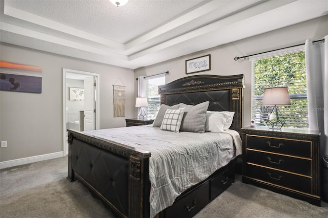 carpeted bedroom featuring a textured ceiling, connected bathroom, and multiple windows