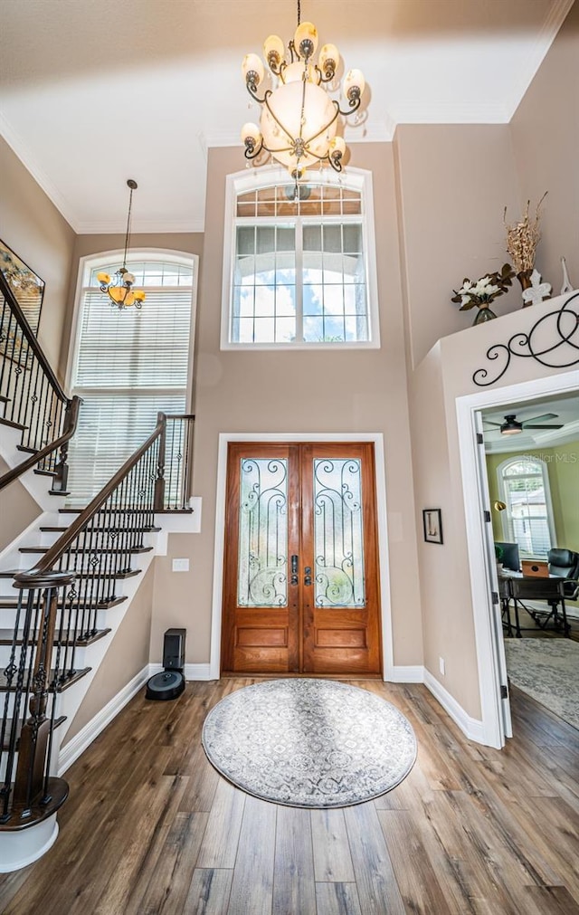 foyer featuring crown molding, hardwood / wood-style floors, a chandelier, and plenty of natural light