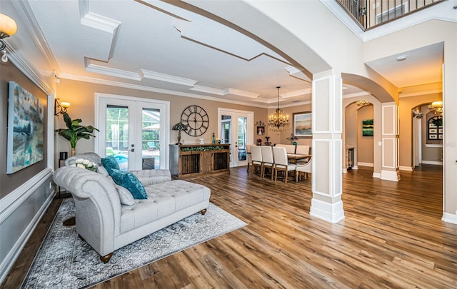 living room with crown molding, a chandelier, french doors, and hardwood / wood-style flooring