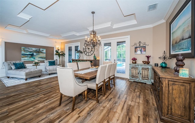 dining room featuring french doors, ornamental molding, a notable chandelier, and hardwood / wood-style floors