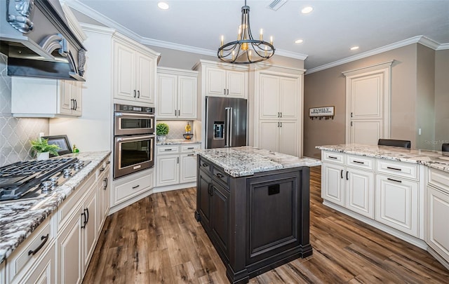 kitchen with appliances with stainless steel finishes, a kitchen island, dark wood-type flooring, and tasteful backsplash