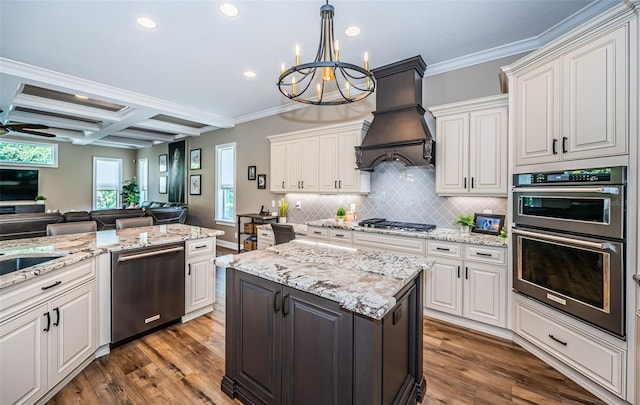 kitchen featuring dark hardwood / wood-style floors, ceiling fan with notable chandelier, hanging light fixtures, stainless steel appliances, and crown molding