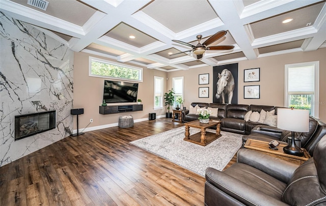 living room with a high end fireplace, hardwood / wood-style floors, ceiling fan, and plenty of natural light