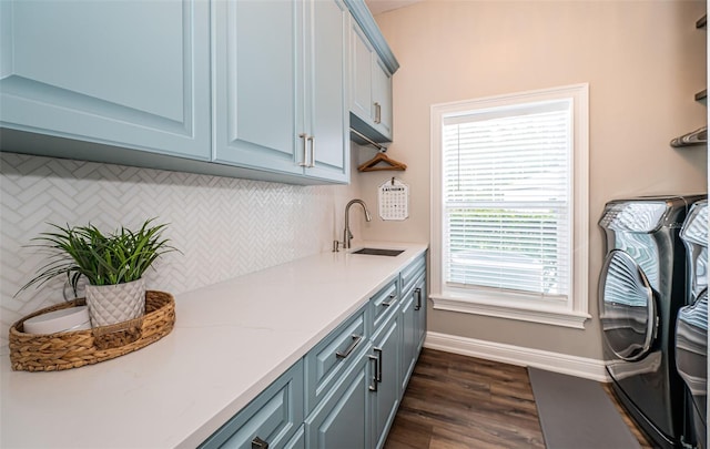 kitchen with tasteful backsplash, sink, dark hardwood / wood-style flooring, light stone countertops, and washing machine and dryer