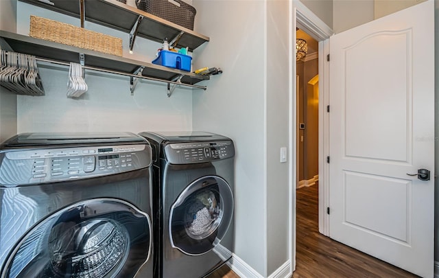 washroom with dark hardwood / wood-style floors and washing machine and dryer