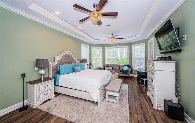 bedroom with crown molding, ceiling fan, dark wood-type flooring, and a raised ceiling