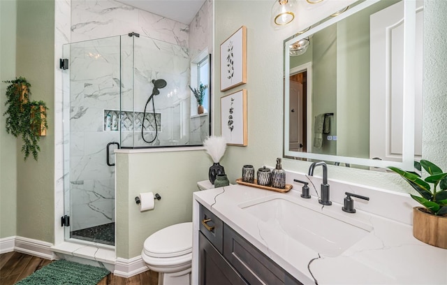 bathroom with wood-type flooring, a shower with door, vanity, and toilet