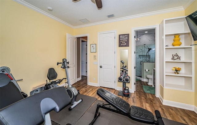 workout area with a textured ceiling, ornamental molding, dark hardwood / wood-style floors, and ceiling fan