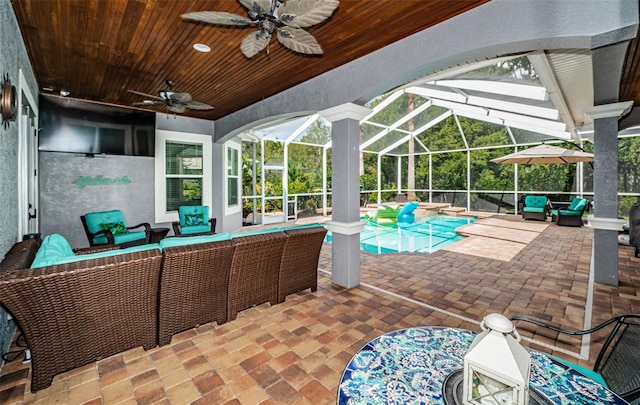 view of swimming pool featuring ceiling fan, an outdoor living space, glass enclosure, and a patio area