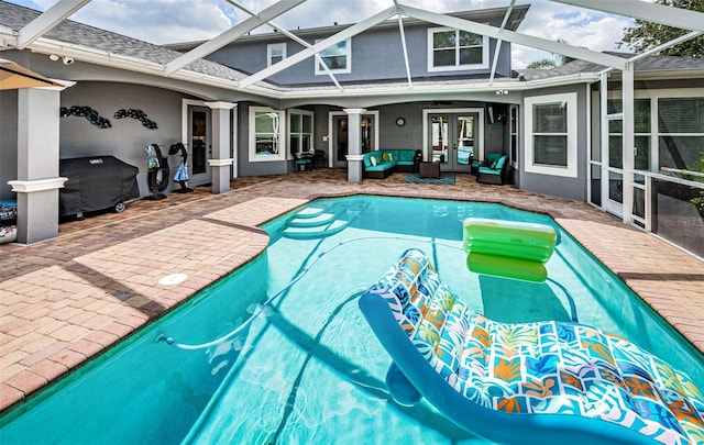 view of swimming pool featuring area for grilling, a lanai, french doors, and a patio area