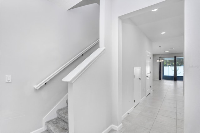 stairs featuring french doors, an inviting chandelier, and tile patterned floors