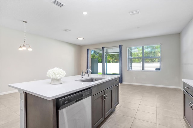 kitchen with dark brown cabinetry, sink, stainless steel dishwasher, a center island with sink, and an inviting chandelier