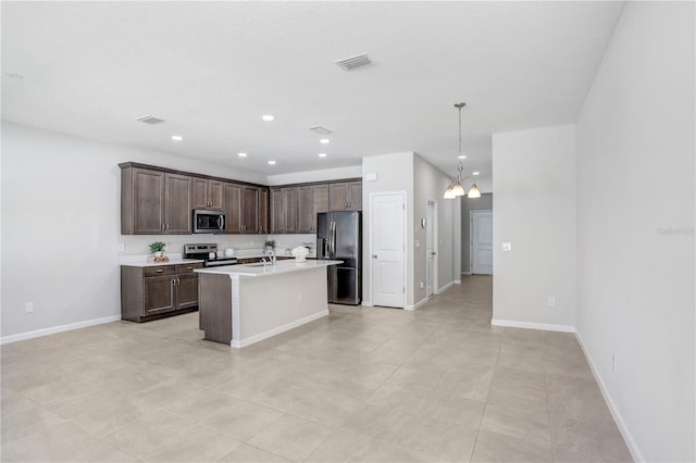 kitchen featuring an island with sink, hanging light fixtures, dark brown cabinets, stainless steel appliances, and an inviting chandelier