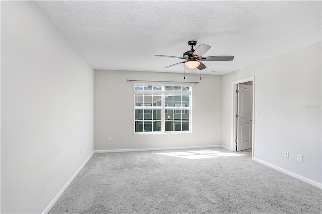 spare room featuring a textured ceiling, ceiling fan, and light carpet